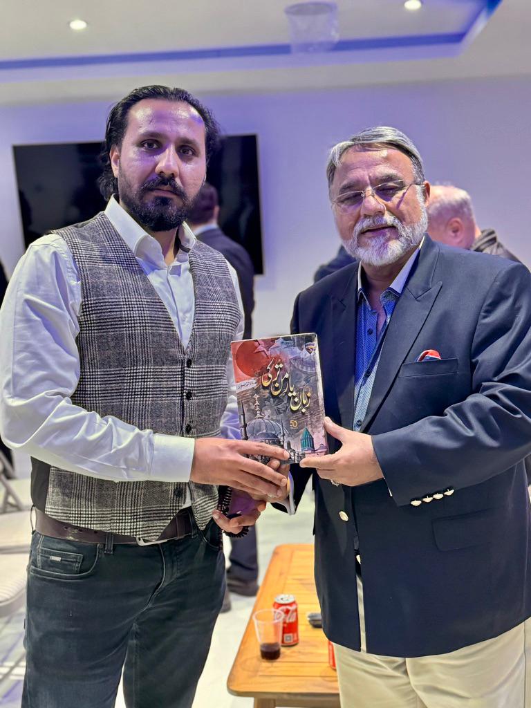 Ahmed Junaid presenting a book at a community event